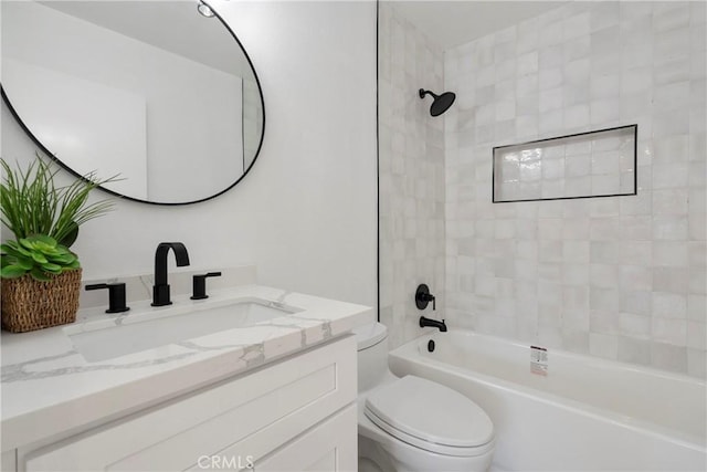 full bathroom featuring vanity, tiled shower / bath combo, and toilet