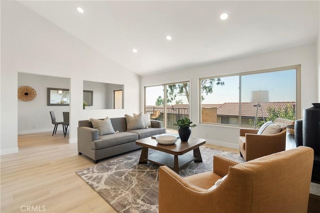 living room featuring high vaulted ceiling and light hardwood / wood-style floors