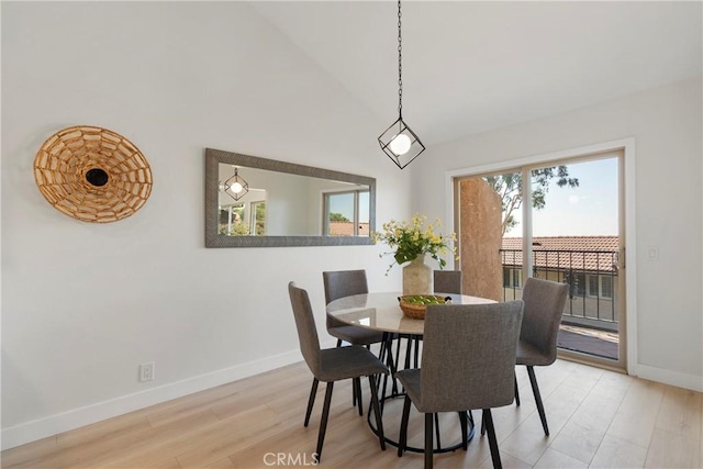 dining room with wood-type flooring and lofted ceiling