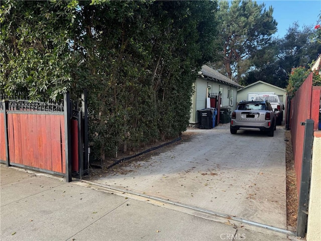 exterior space featuring concrete driveway and fence