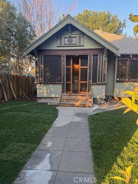 back of house featuring a yard and a sunroom