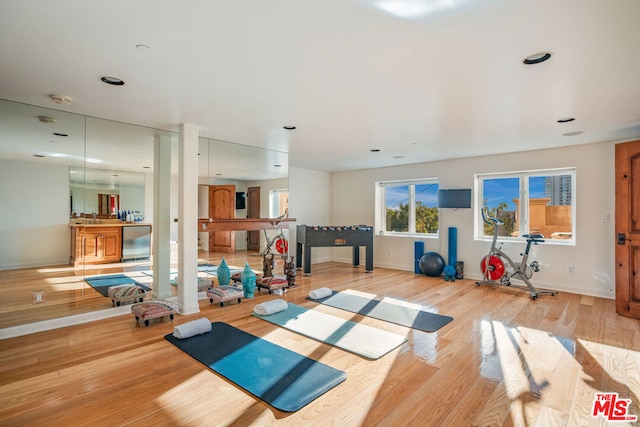 exercise room with light wood-type flooring