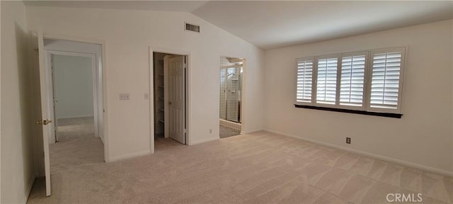 unfurnished bedroom featuring lofted ceiling and light colored carpet