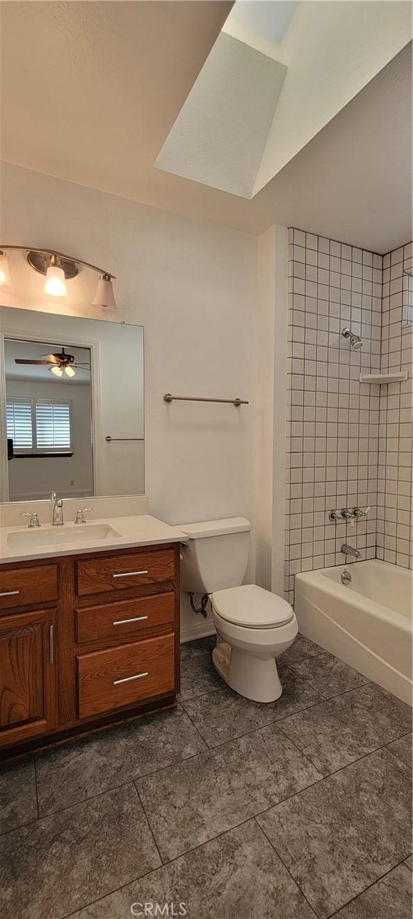 full bathroom featuring ceiling fan, toilet, vanity, and tiled shower / bath