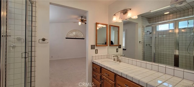 bathroom featuring ceiling fan, walk in shower, and vanity