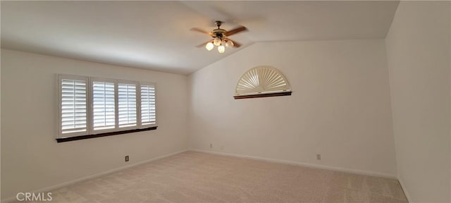 spare room with vaulted ceiling, ceiling fan, and light carpet