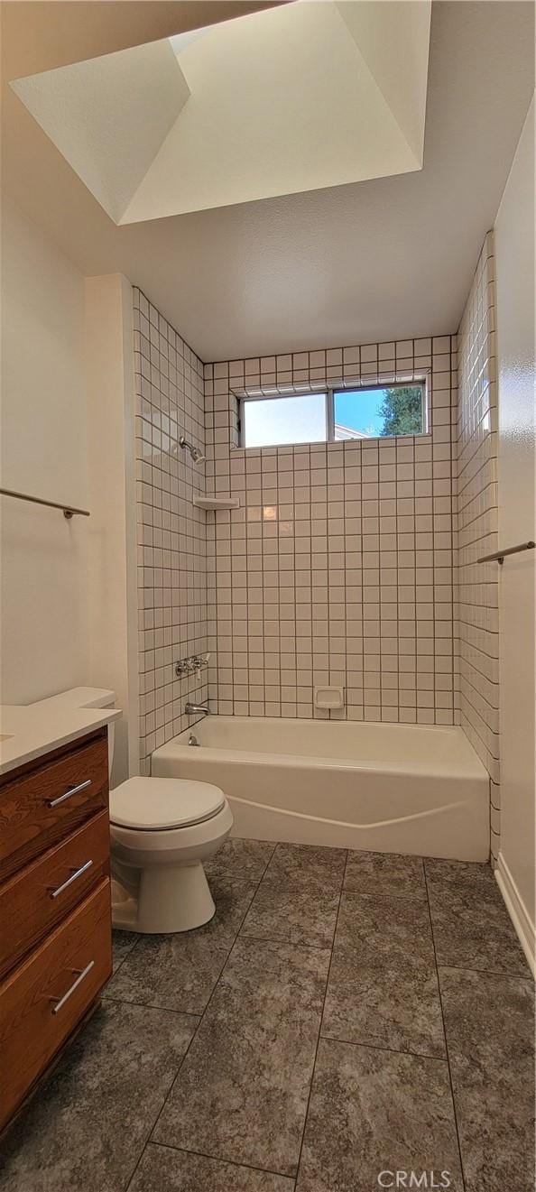 full bathroom with toilet, vanity, tiled shower / bath combo, and tile patterned flooring