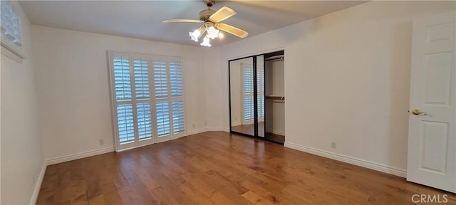 unfurnished bedroom with ceiling fan, a closet, and hardwood / wood-style floors