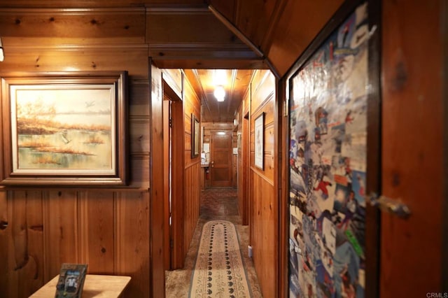 hall featuring carpet floors and wood walls