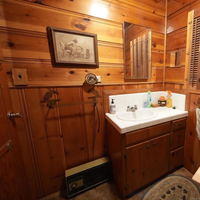 bathroom featuring vanity, wooden walls, and tasteful backsplash