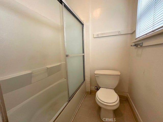 bathroom with tile patterned floors, toilet, and enclosed tub / shower combo