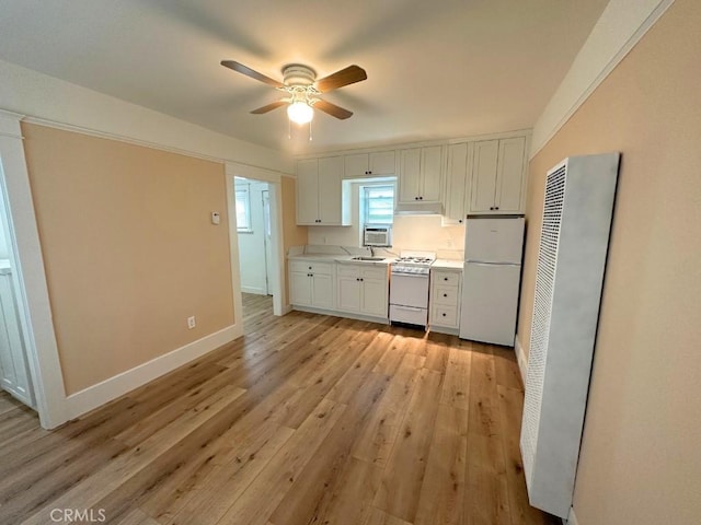 kitchen with light wood-type flooring, white appliances, ceiling fan, sink, and white cabinetry