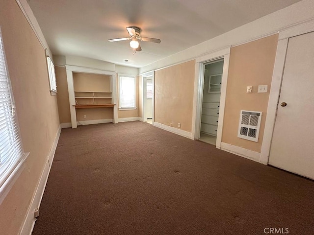 unfurnished bedroom featuring carpet flooring, heating unit, and ceiling fan