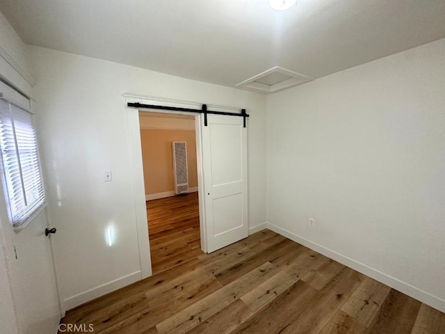 spare room with hardwood / wood-style floors and a barn door