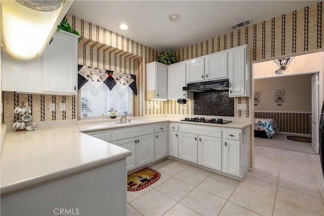 kitchen featuring light tile patterned floors, black gas cooktop, white cabinets, and sink