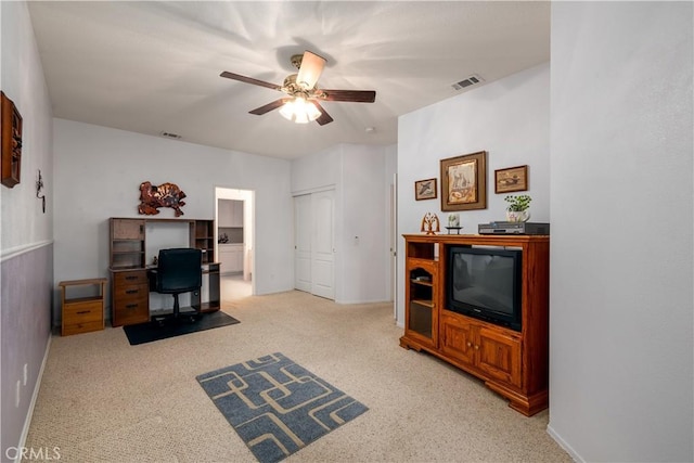 carpeted home office with ceiling fan