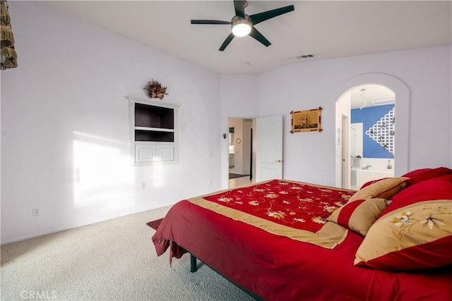 carpeted bedroom featuring ensuite bath and ceiling fan