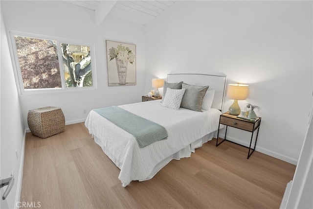 bedroom with beamed ceiling, light hardwood / wood-style flooring, and wood ceiling