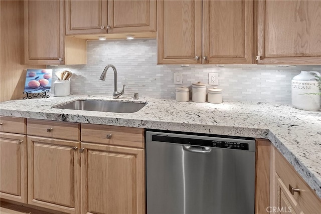 kitchen featuring light stone countertops, decorative backsplash, sink, and stainless steel dishwasher