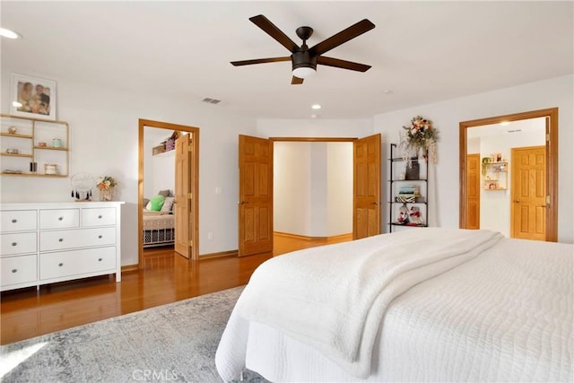 bedroom featuring ensuite bathroom, ceiling fan, and dark wood-type flooring