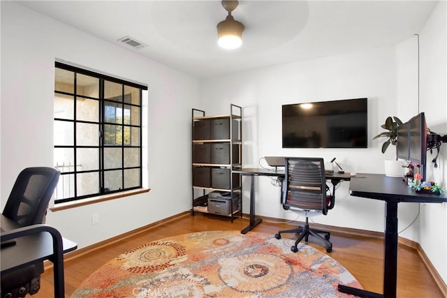 home office featuring hardwood / wood-style floors and ceiling fan