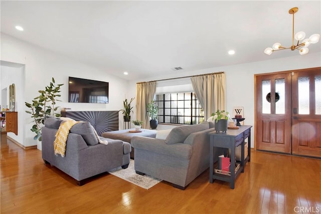 living room featuring plenty of natural light, hardwood / wood-style floors, and a notable chandelier