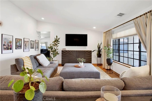 living room featuring light hardwood / wood-style floors and vaulted ceiling