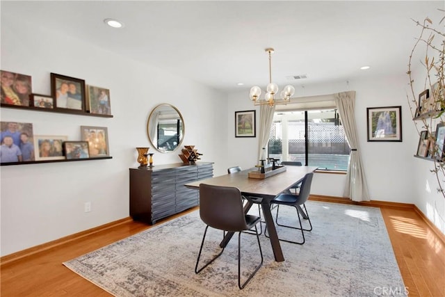 dining area featuring light hardwood / wood-style floors and a notable chandelier