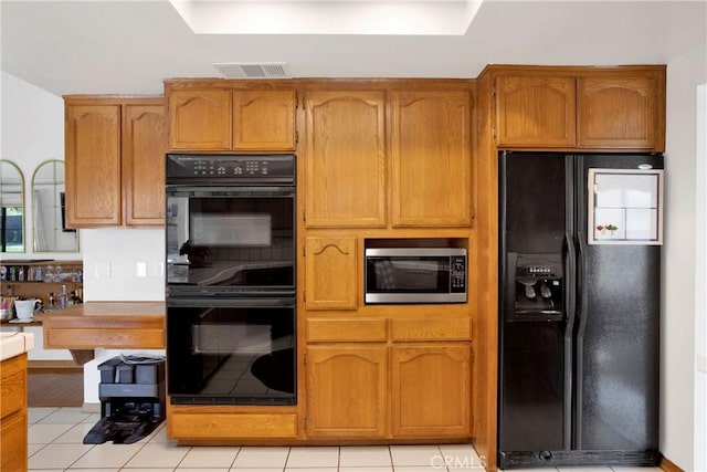 kitchen featuring light tile patterned floors and black appliances