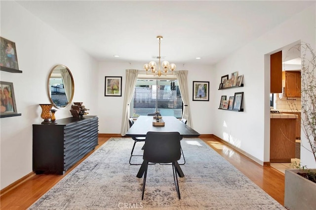 dining area featuring light hardwood / wood-style floors and a notable chandelier