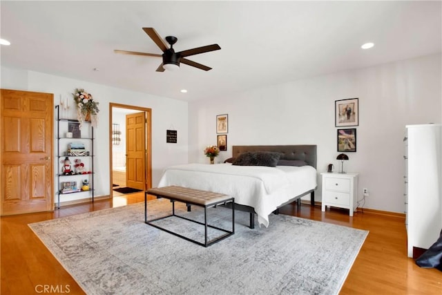 bedroom with hardwood / wood-style floors, ensuite bath, and ceiling fan