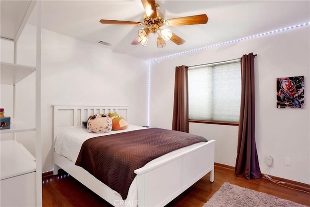 bedroom with dark hardwood / wood-style flooring and ceiling fan