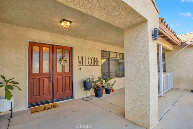 view of exterior entry featuring covered porch