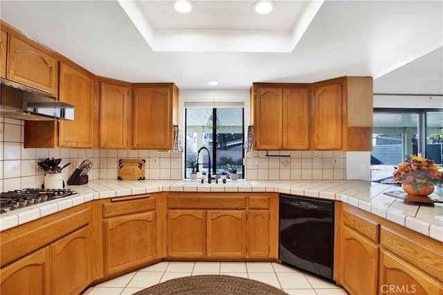 kitchen featuring dishwasher, tile countertops, plenty of natural light, and sink