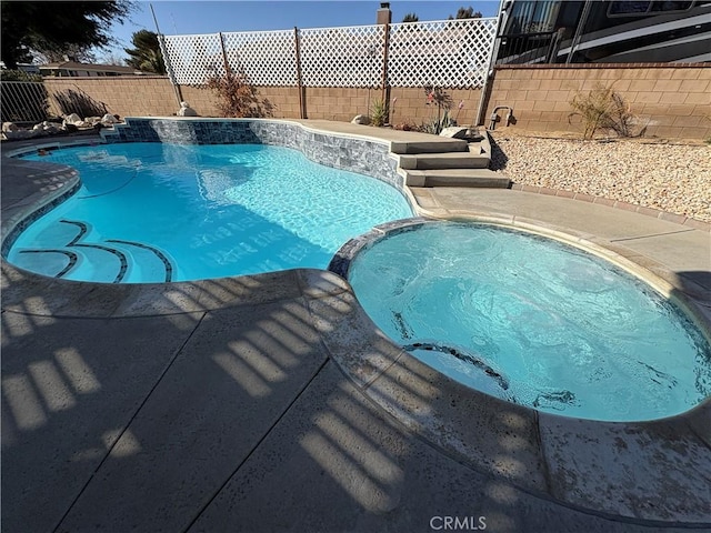 view of pool with an in ground hot tub