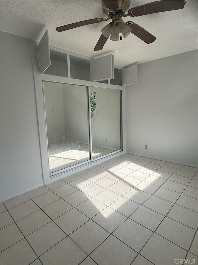 tiled empty room with a textured ceiling