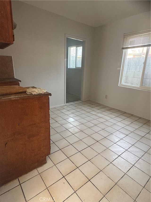 spare room featuring light tile patterned flooring and plenty of natural light