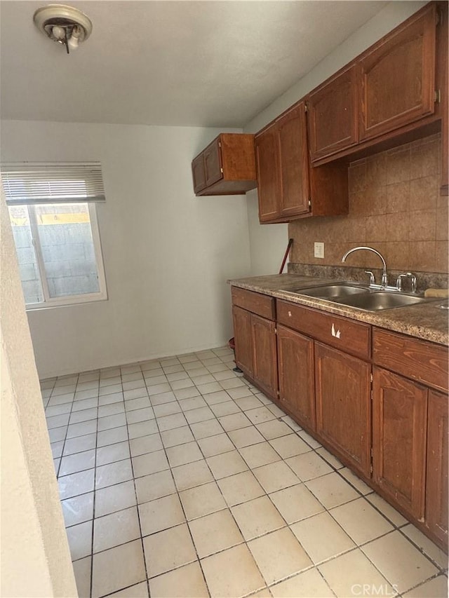 kitchen featuring light tile patterned floors, sink, and backsplash