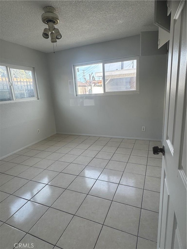 tiled spare room featuring ceiling fan