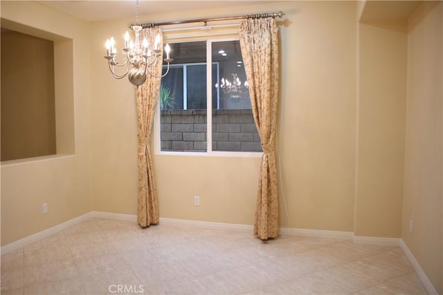 tiled spare room with an inviting chandelier