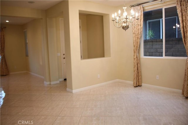 tiled spare room featuring a notable chandelier