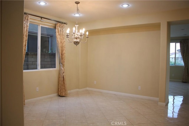 tiled spare room featuring a chandelier