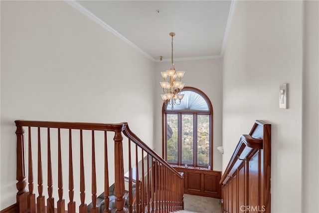 staircase featuring crown molding and an inviting chandelier