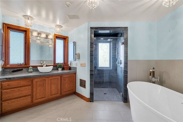 bathroom with tile patterned floors, vanity, shower with separate bathtub, and an inviting chandelier