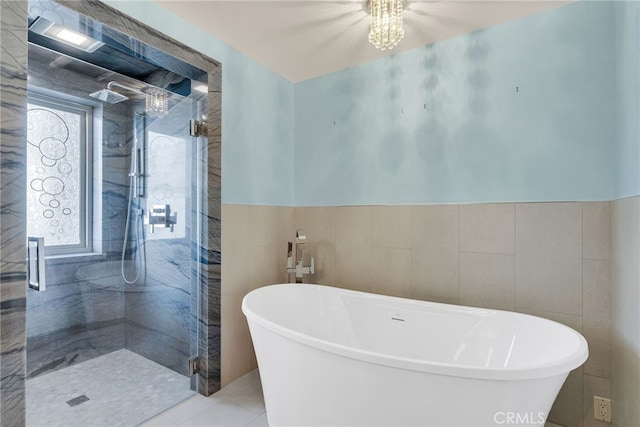 bathroom featuring tile patterned flooring, a notable chandelier, tile walls, and plus walk in shower