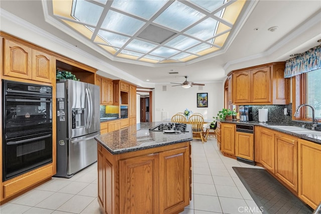 kitchen with tasteful backsplash, stainless steel appliances, crown molding, sink, and a center island