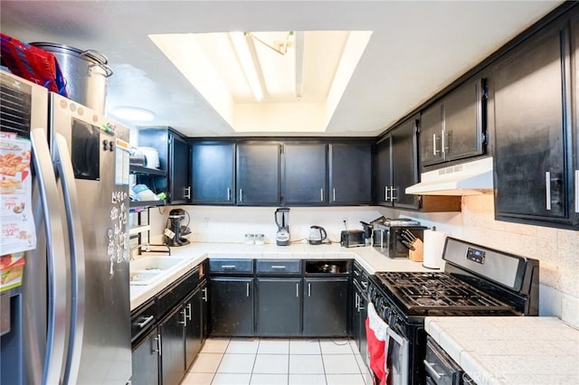 kitchen featuring tile countertops, sink, light tile patterned floors, tasteful backsplash, and stainless steel appliances