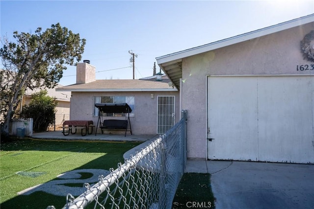 rear view of house with a patio and a lawn