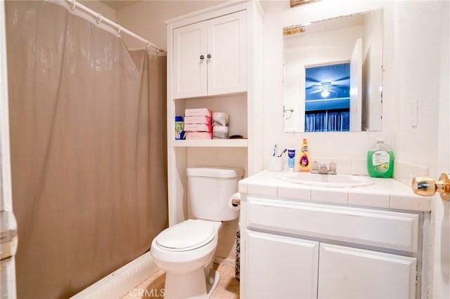 full bath with curtained shower, vanity, and toilet