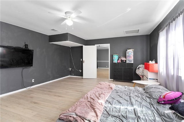 bedroom with a ceiling fan, baseboards, visible vents, and light wood finished floors